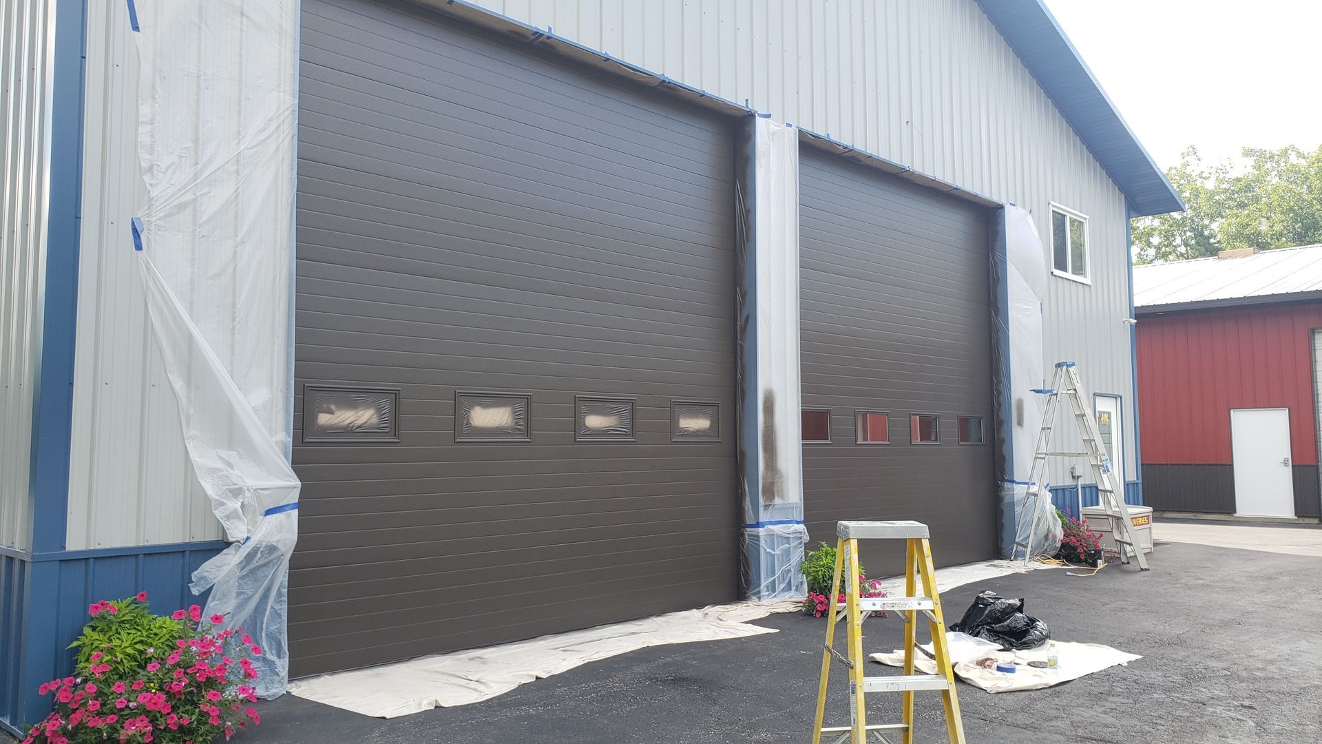 A garage door is being painted in front of a building.
