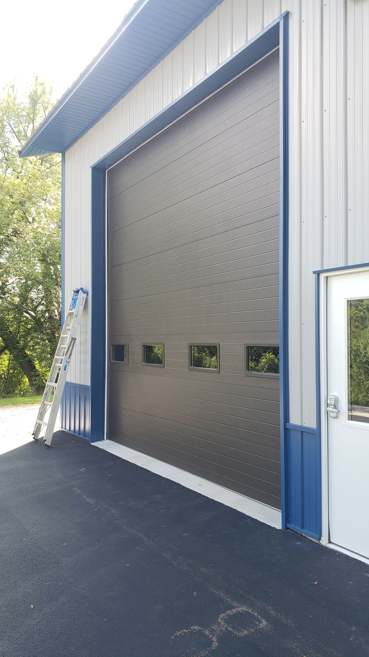 A large garage door with a ladder leaning against it.
