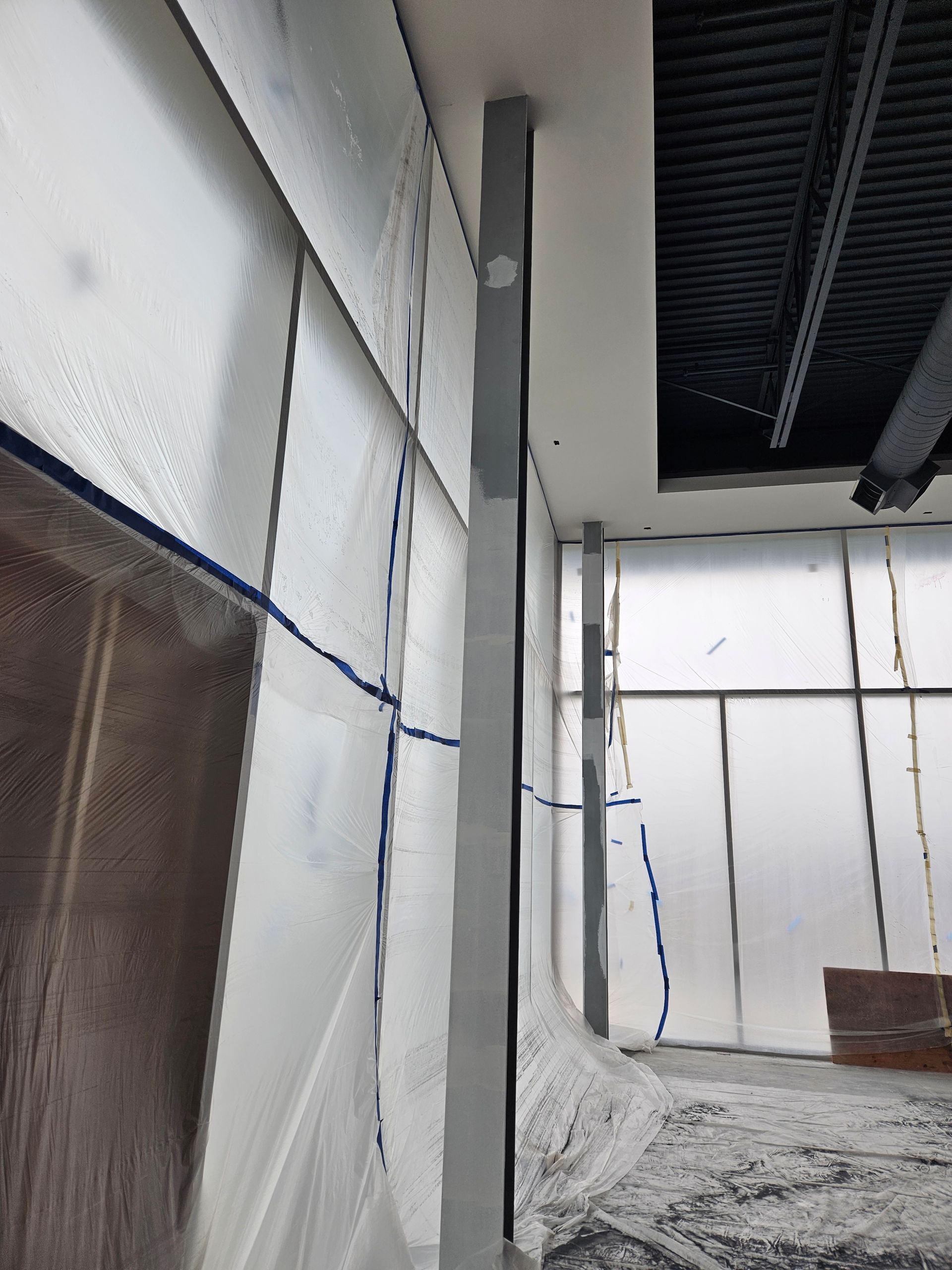 A room with a lot of windows covered in plastic