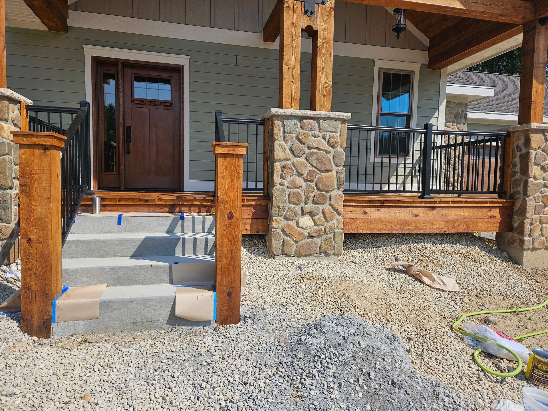 A house with a porch and stairs is being built.
