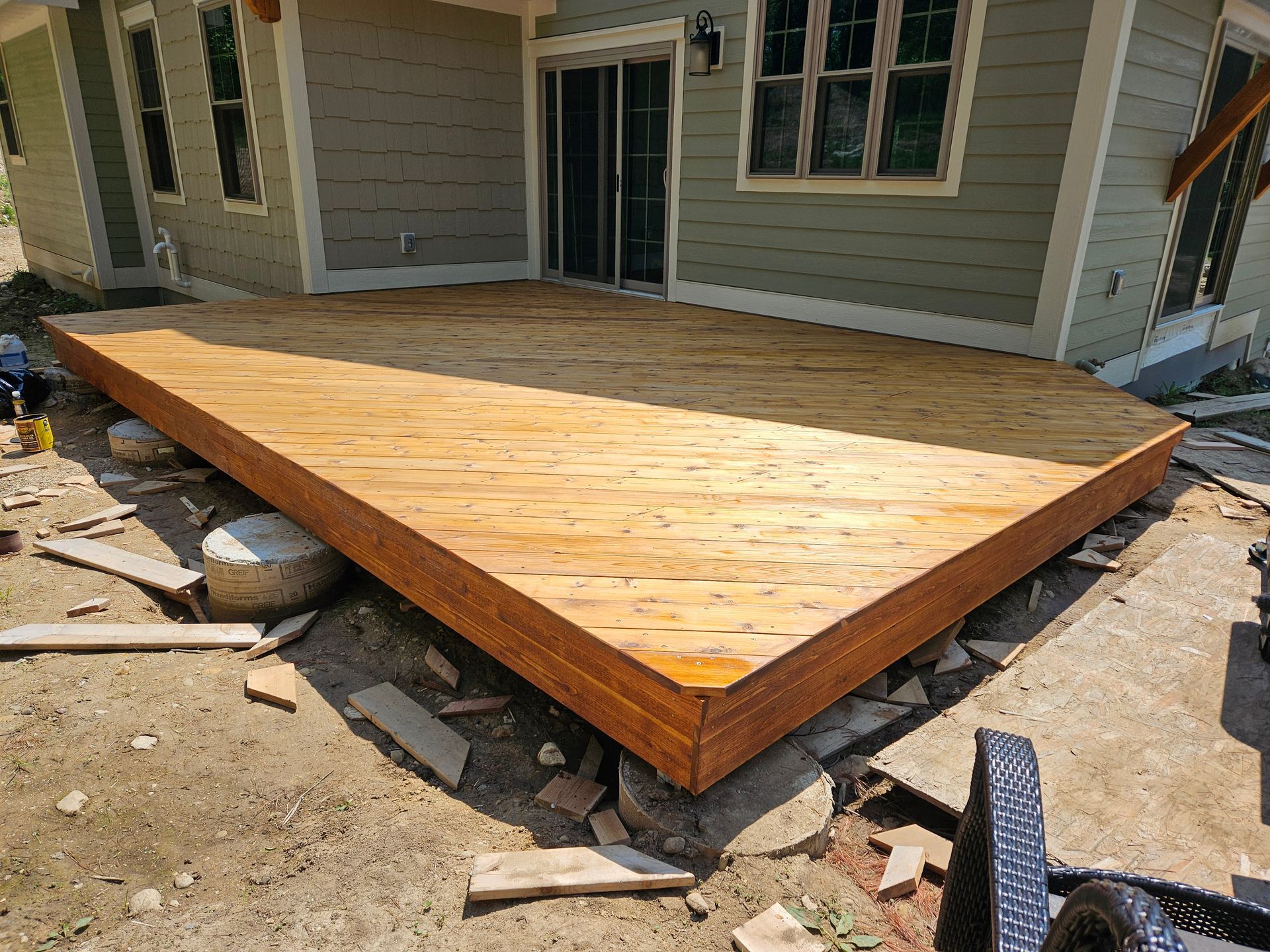 A wooden deck is being built in front of a house.