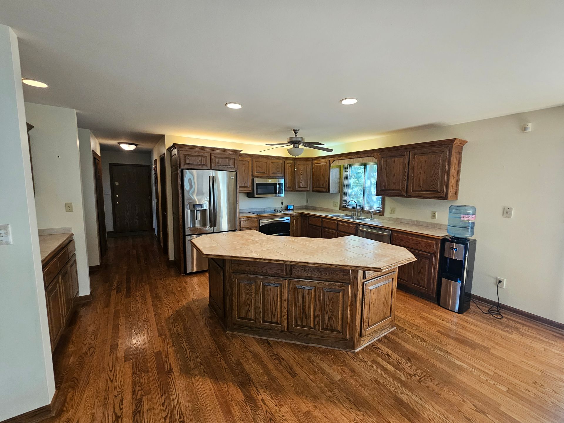 A kitchen with a large island in the middle of it and hardwood floors.