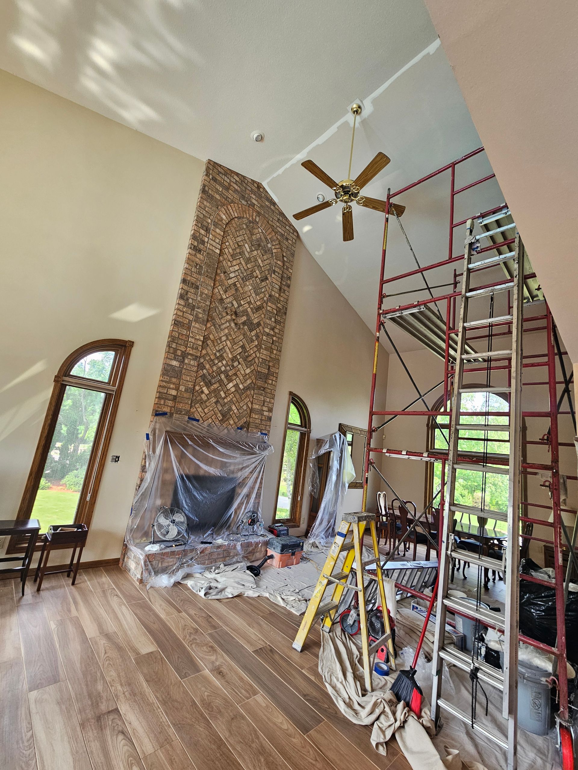A large room with a fireplace and a ceiling fan
