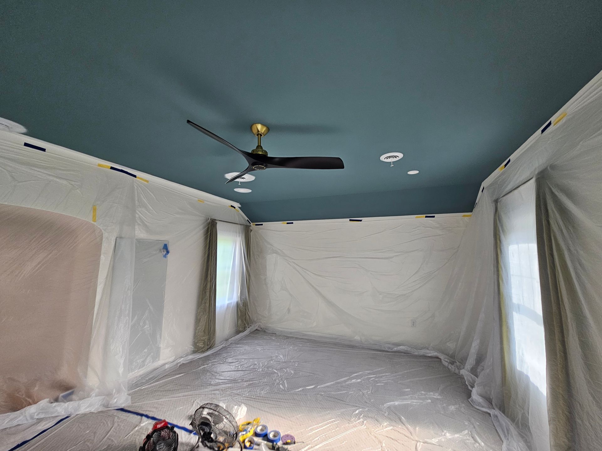 A room with a blue ceiling and a ceiling fan.