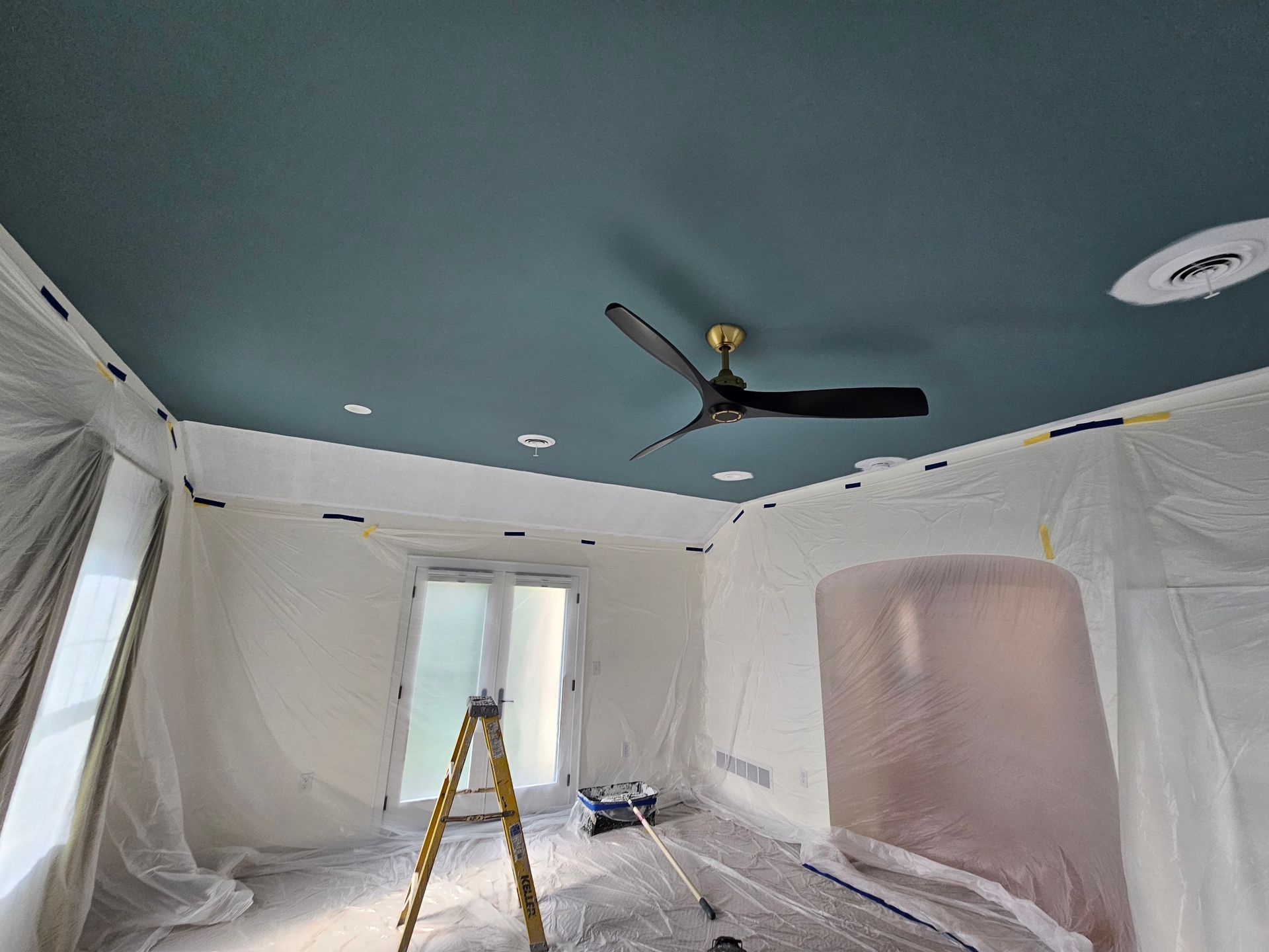 A room with a blue ceiling and a ceiling fan.