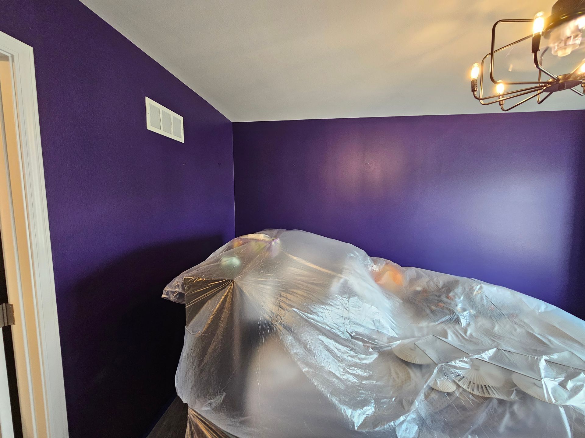 A room with purple walls and a plastic bag on the floor.