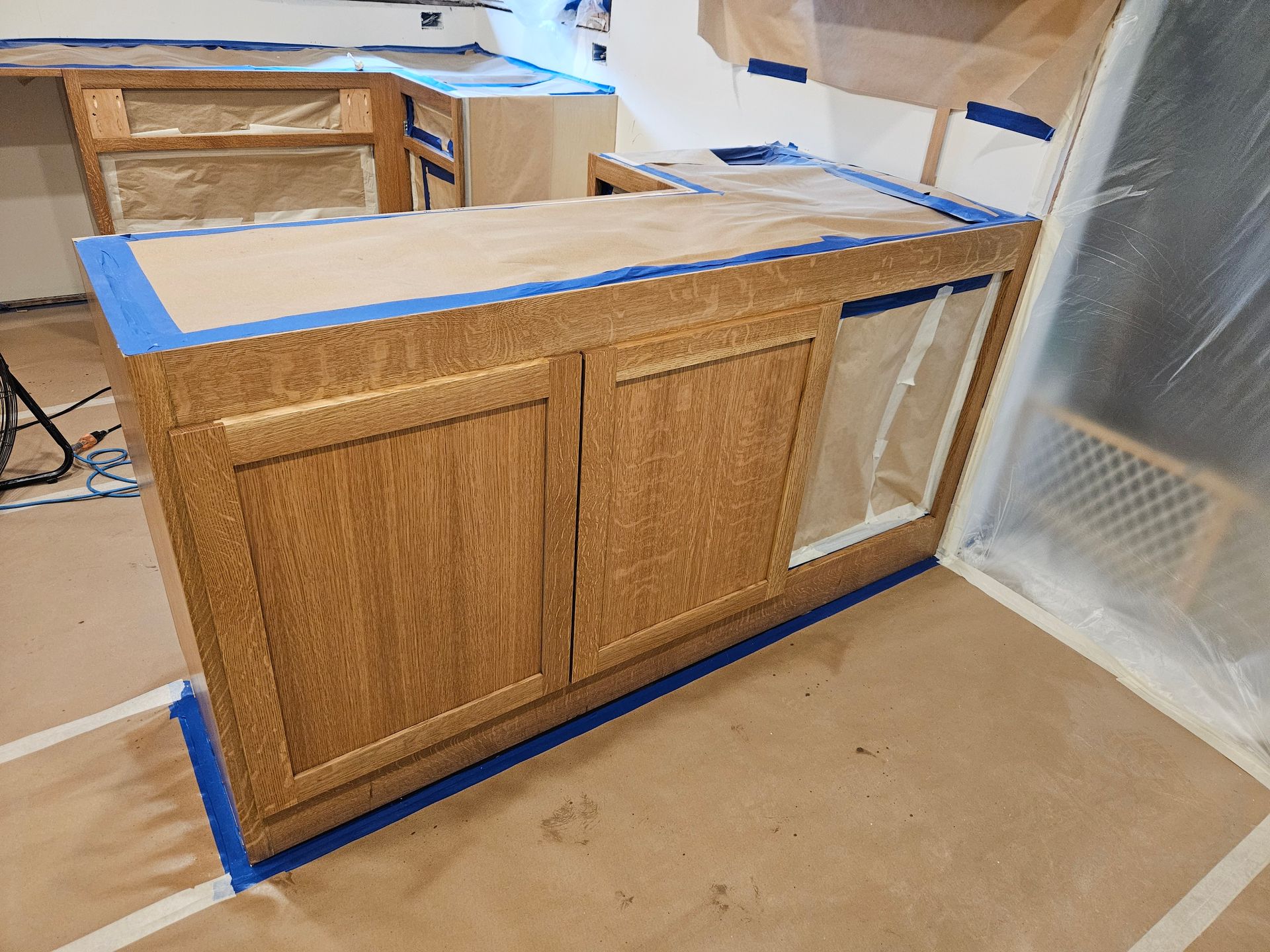 A wooden cabinet is being painted in a kitchen.