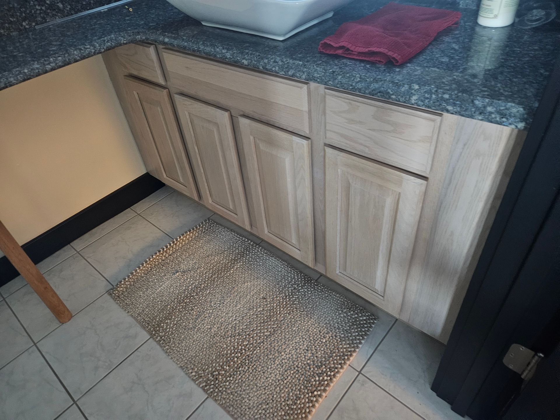 A bathroom with a sink and a rug on the floor