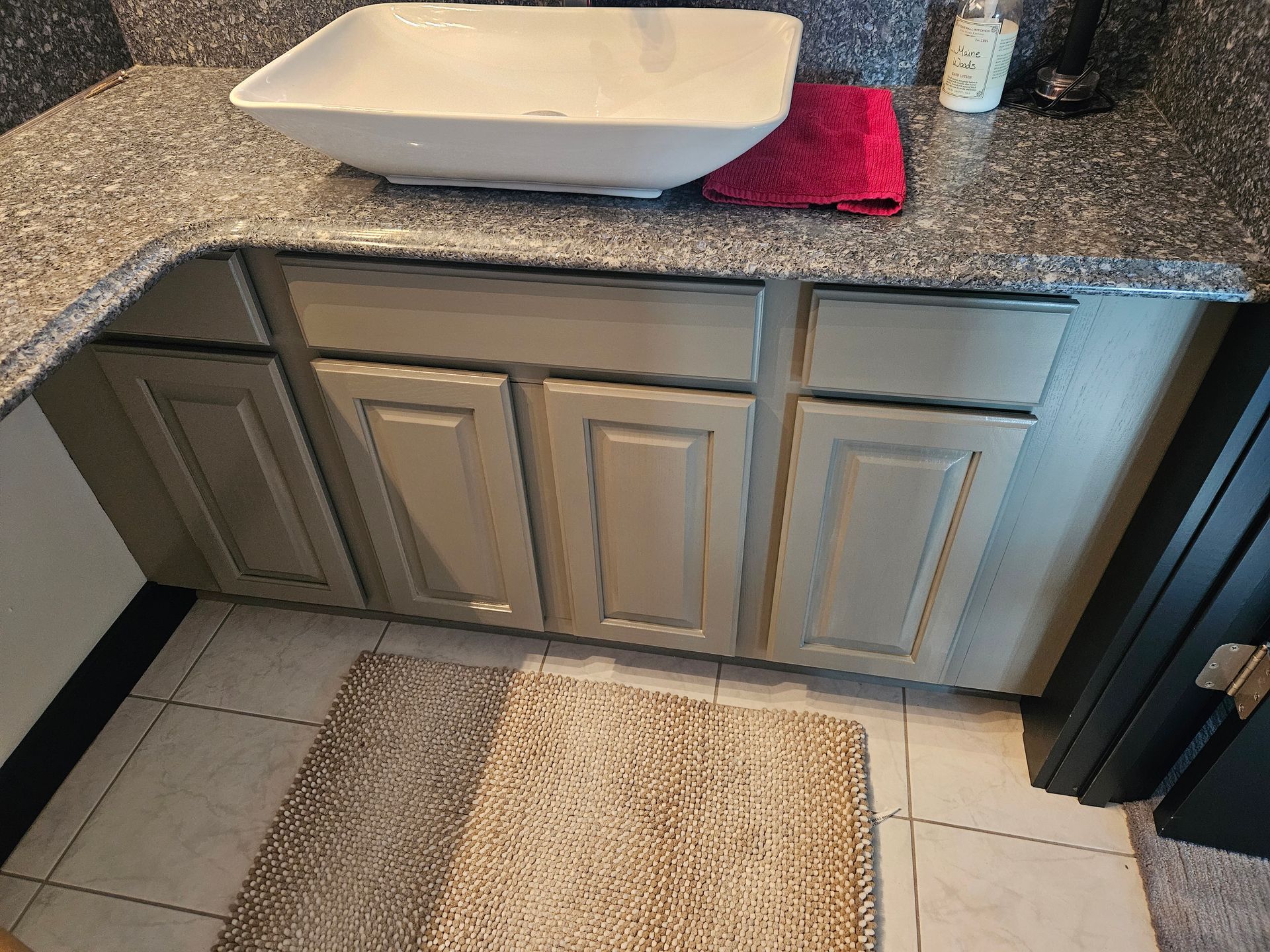 A bathroom with a sink and a rug on the floor
