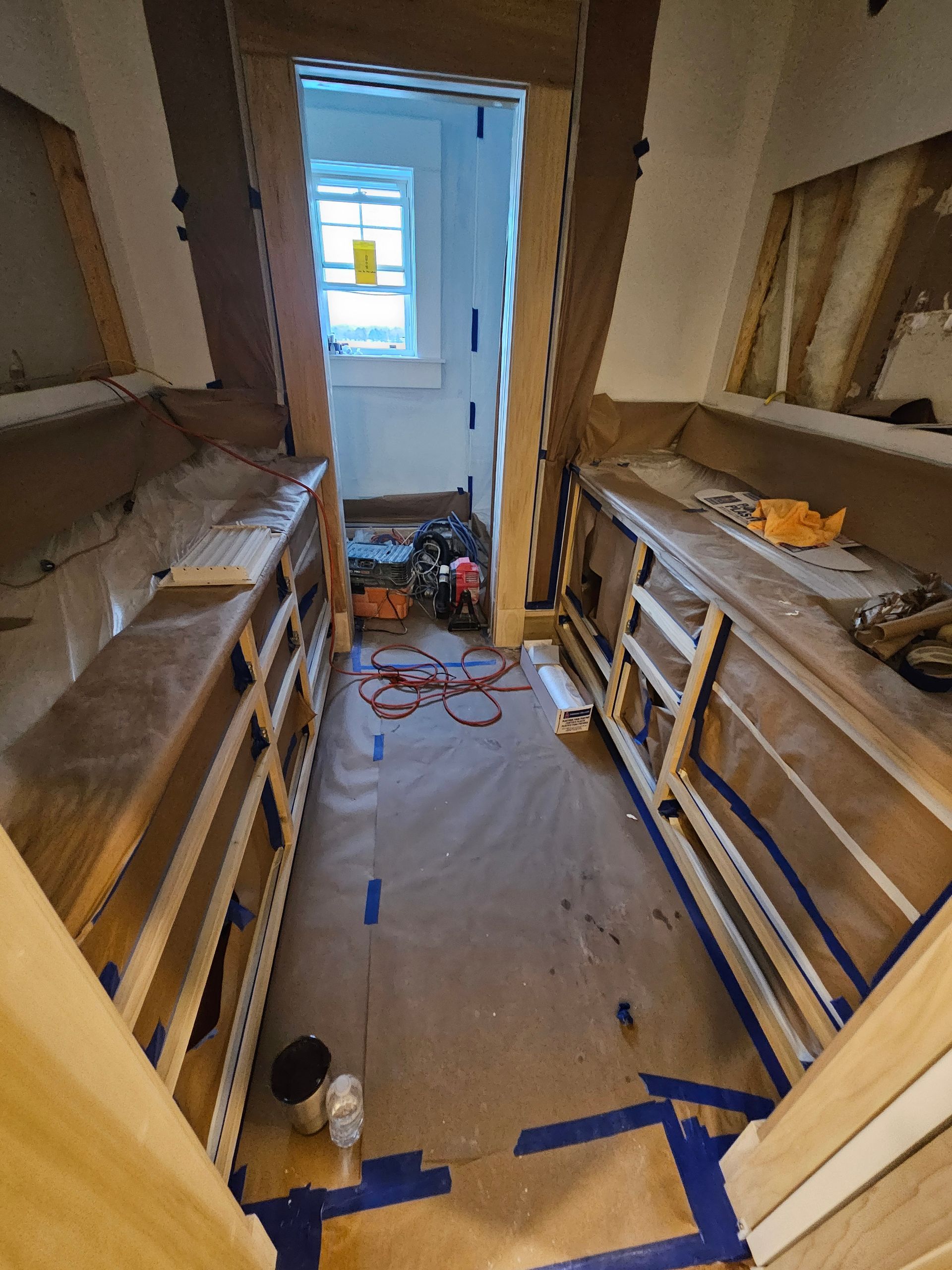 A room that is being remodeled with blue tape on the floor
