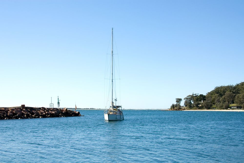 A Sailboat Is Floating On Top Of A Body Of Water — East Coast Air In Port Stephens, NSW
