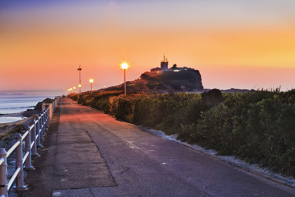 A Road Leading To A Lighthouse On Top Of A Hill At Sunset — East Coast Air In Singleton, NSW