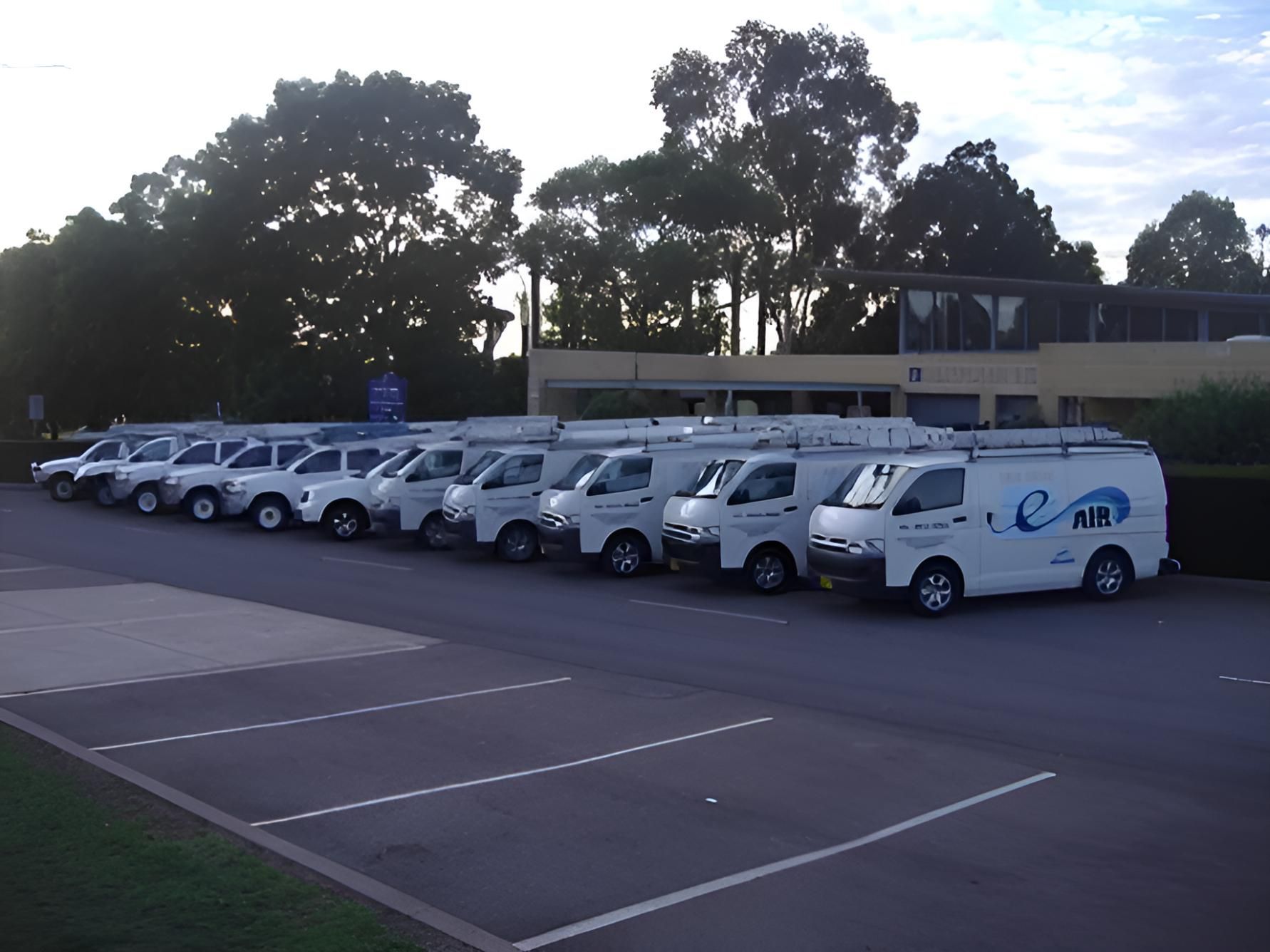 A Row Of White Vans Parked In A Parking Lot — East Coast Air In East Maitland, NSW