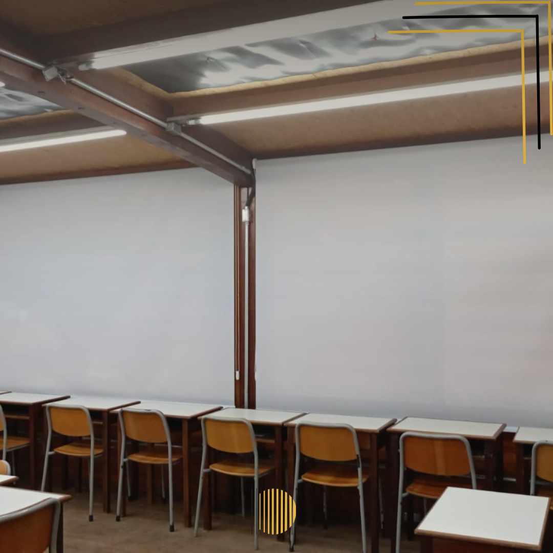 Uma sala de aula com mesas, persianas e cadeiras e um quadro branco