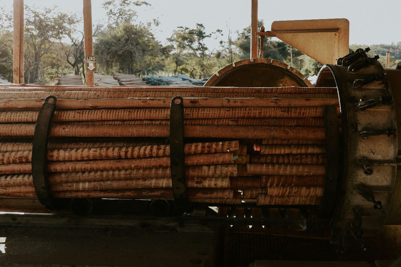 Uma pilha de toras está em cima de uma carroça de madeira.