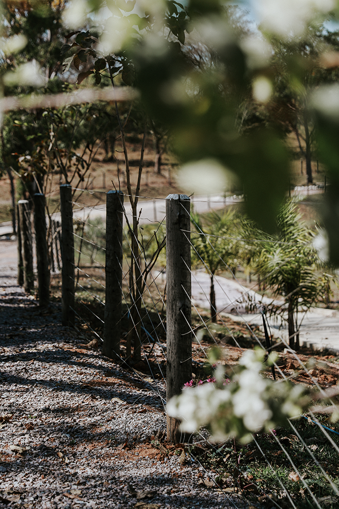 Uma cerca de arame farpado circunda um caminho de terra em um campo.