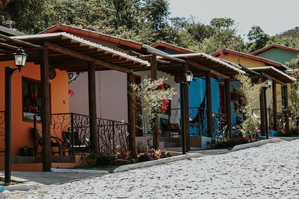 Uma fileira de casas coloridas com varandas em uma rua de paralelepípedos.