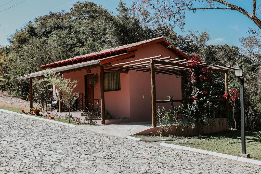 Uma pequena casa está situada na beira de uma estrada de cascalho.