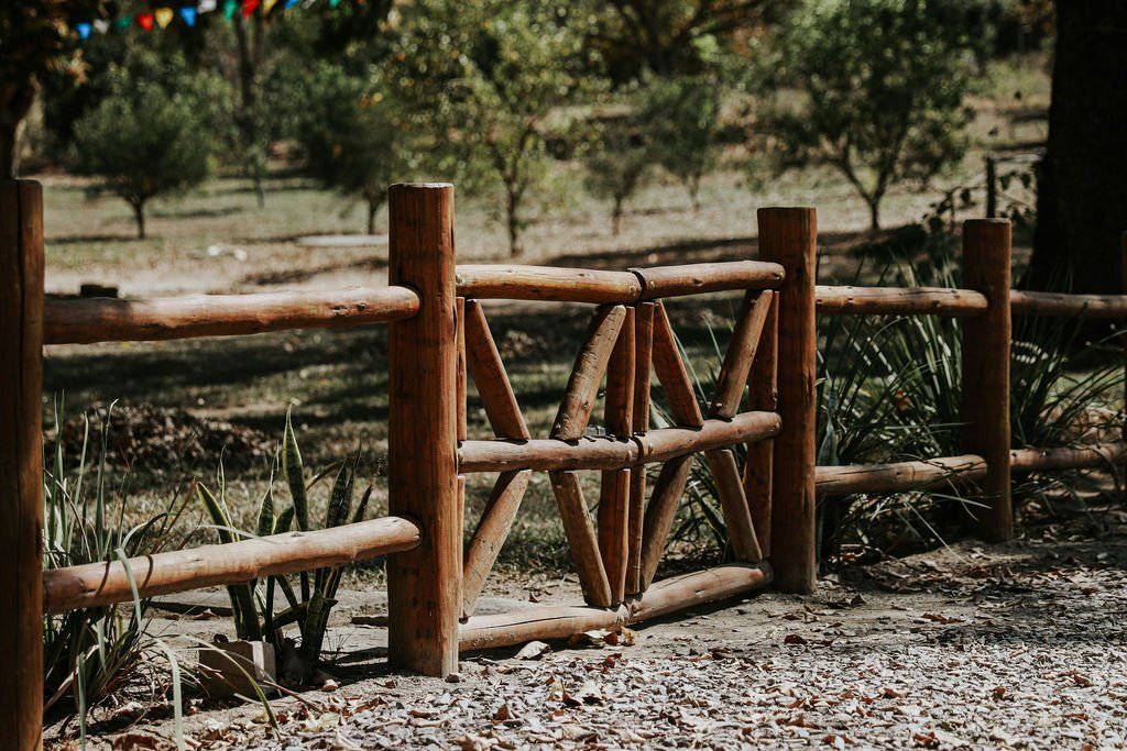Uma cerca de madeira com um portão no meio de um campo.