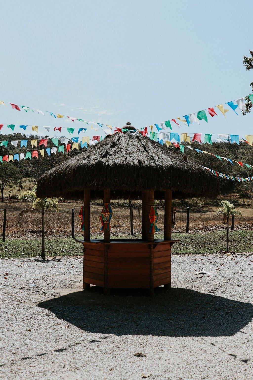 Uma pequena cabana com telhado de palha cercada por bandeiras.