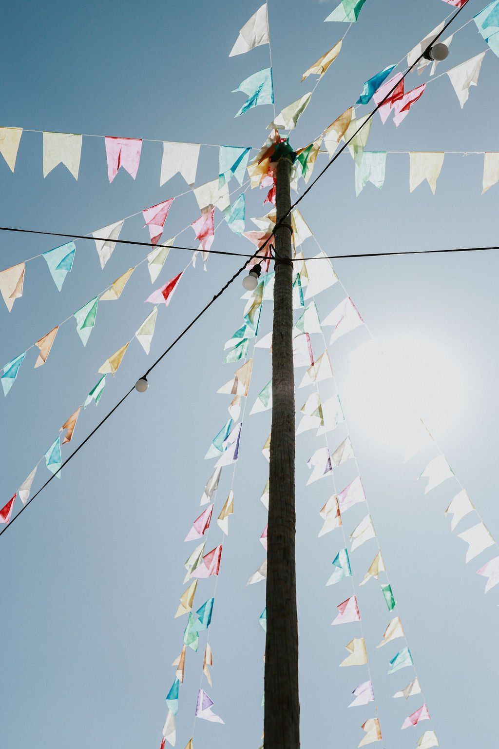 Um monte de bandeiras coloridas estão penduradas em um mastro.