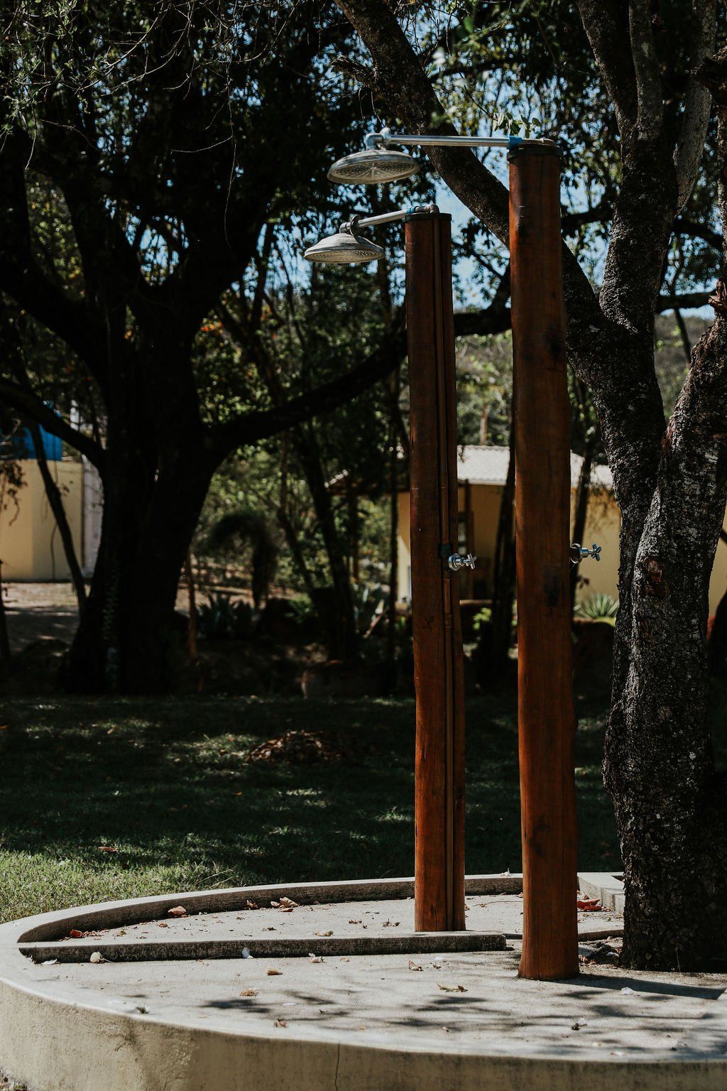 Um chuveiro externo de madeira cercado por árvores em um parque.