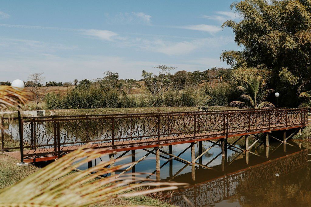 Uma ponte sobre um corpo de água com árvores ao fundo.