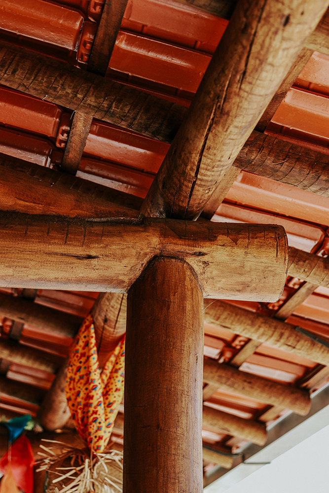 Uma estrutura de madeira com telhado de telhas e vigas de madeira.