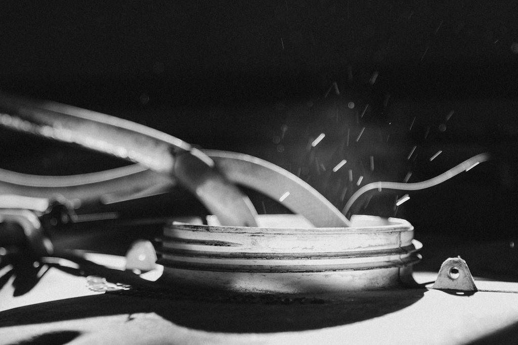 Uma foto em preto e branco de um objeto de metal com faíscas saindo dele