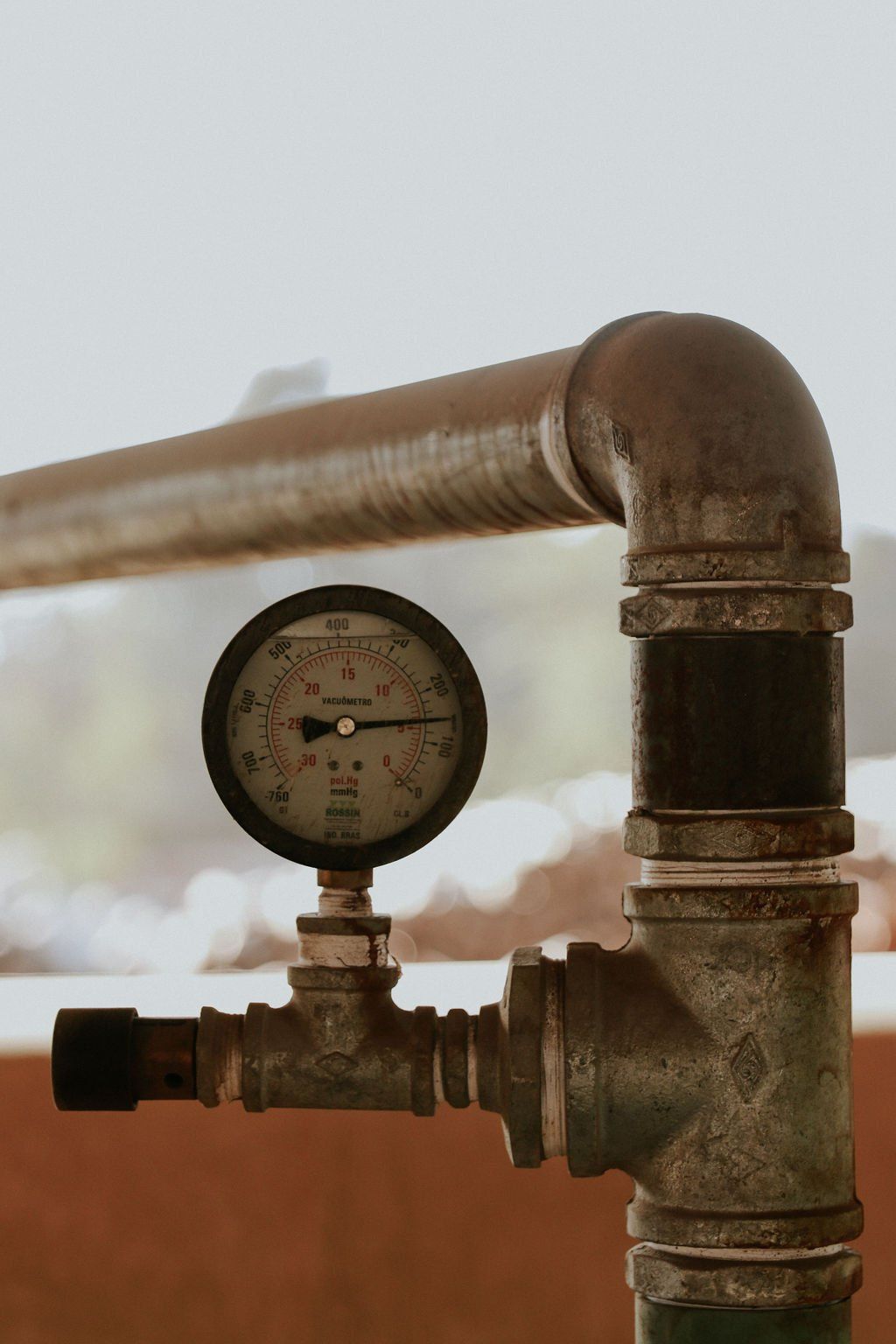 Um close de um cano com um manômetro conectado a ele.