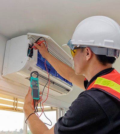 Plumbing Contractors — Electrician Fixing a Air Conditioner in Irving , TX