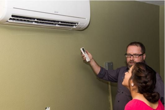 Man Adjusting Air Conditioner's Temperature — Irving, TX — Henry's Service All