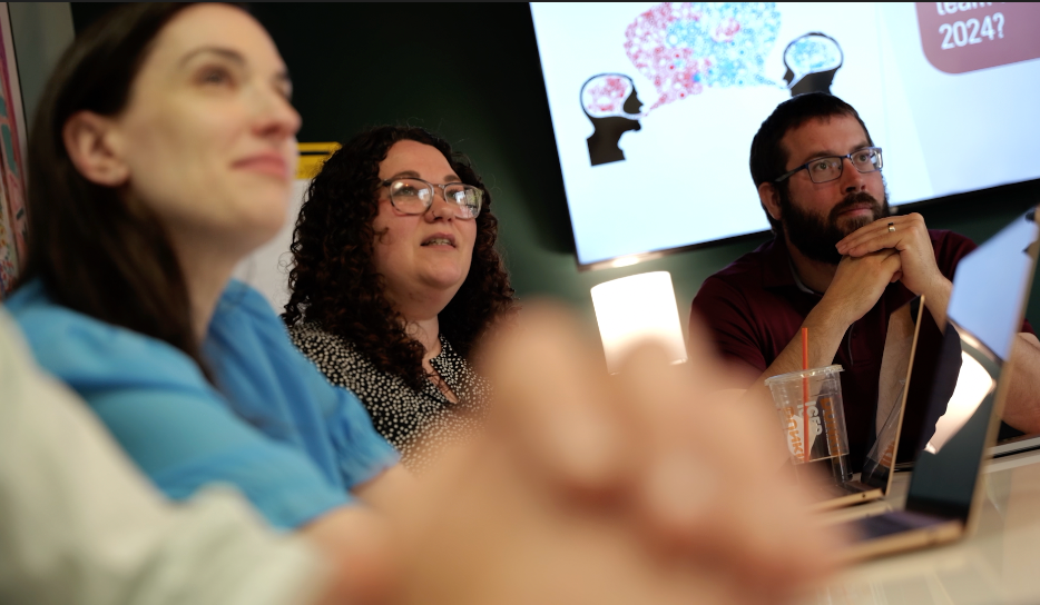 A group of people are sitting around a table and looking at something