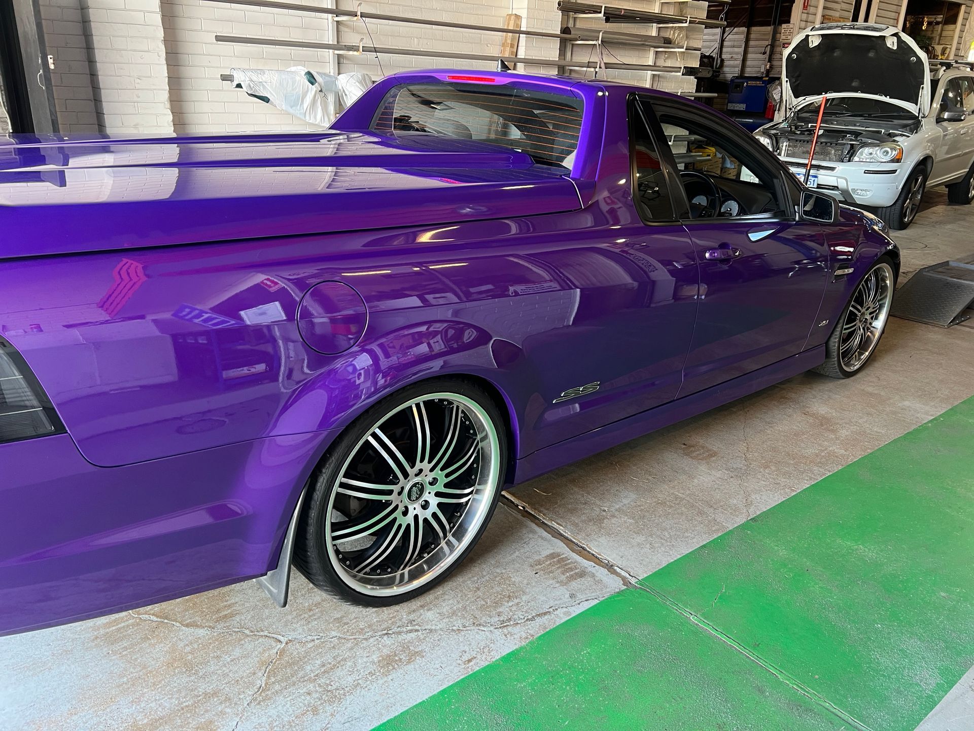Purple utility vehicle with custom wheels in a garage.