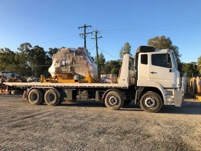 A White Tow Truck Is Carrying A Large Object On A Flatbed Trailer — Little Mates Towing & Transport Pty Ltd In Glenlee, QLD