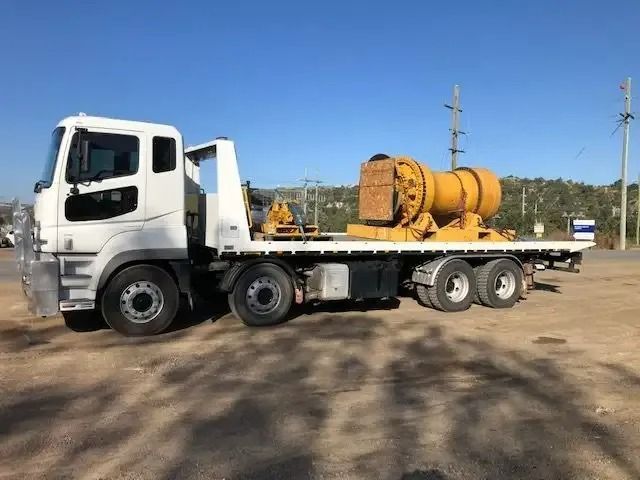 A White Truck With A Flatbed Is Parked In A Dirt Lot — Little Mates Towing & Transport Pty Ltd In Emerald, QLD