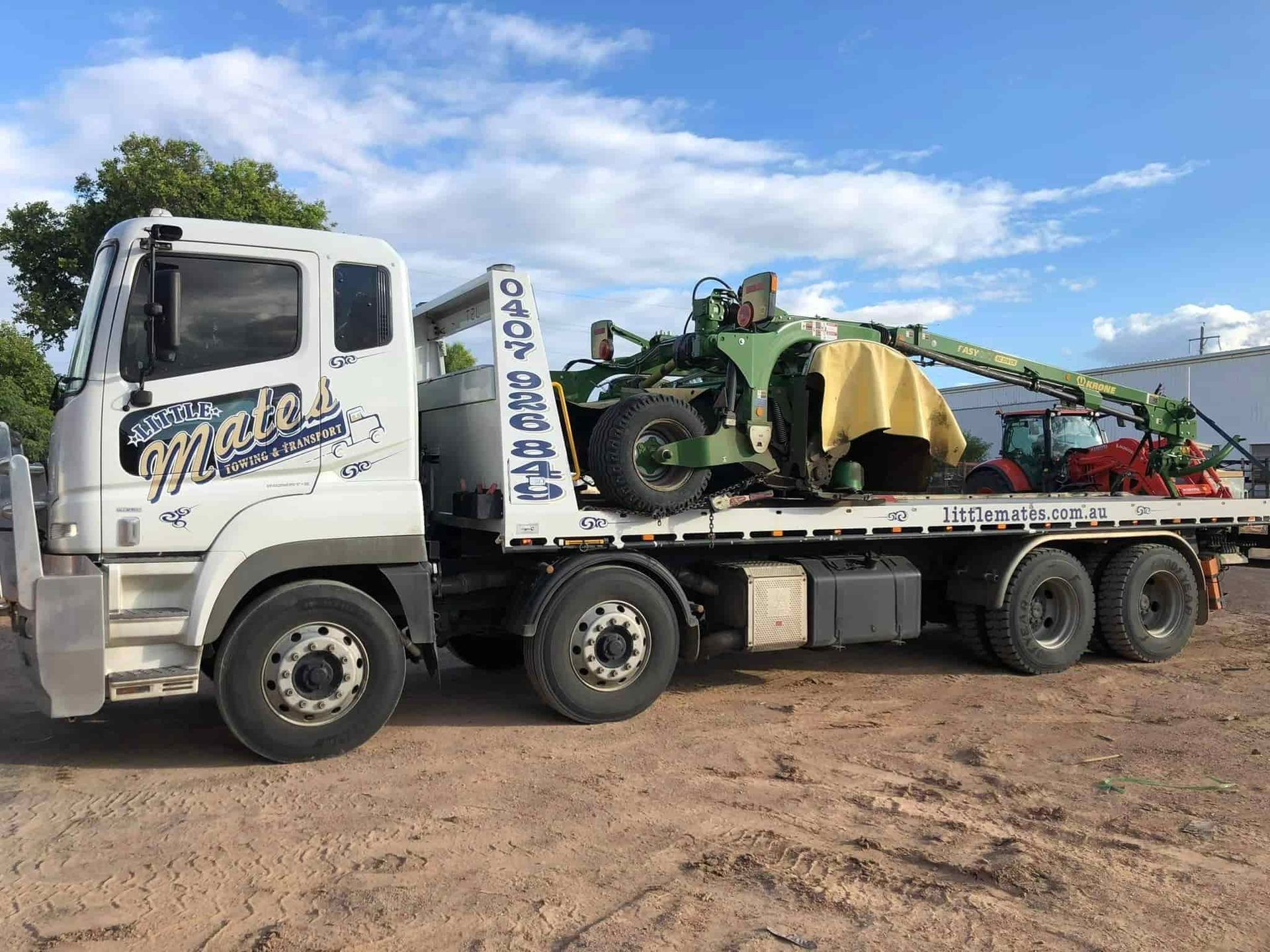 A White Tow Truck With A Green Tractor On The Back — Little Mates Towing & Transport Pty Ltd In Gladstone, QLD