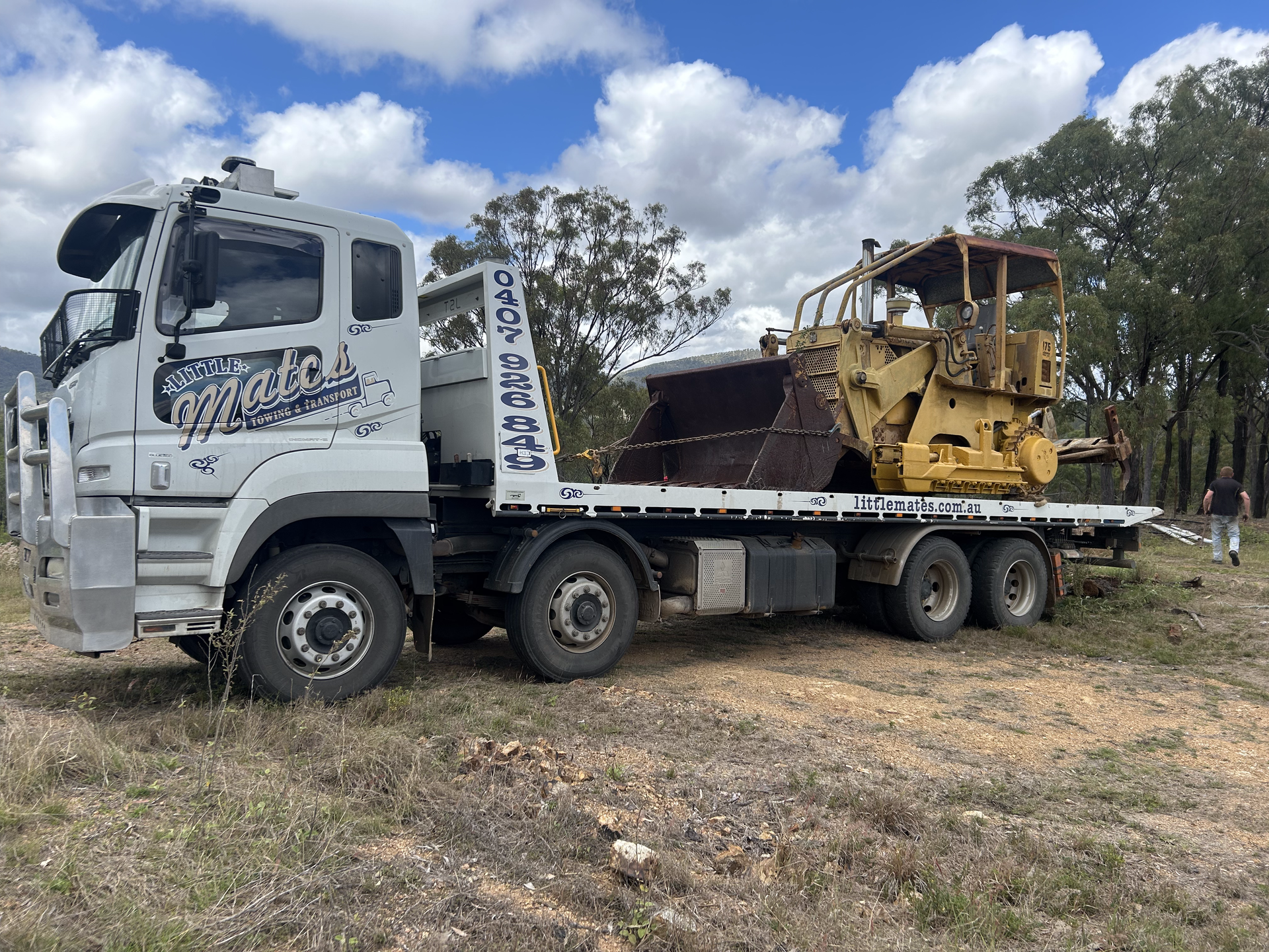 A tow truck with a bulldozer on the back is parked in a field — Little Mates Towing & Transport Pty Ltd In Glenlee, QLD