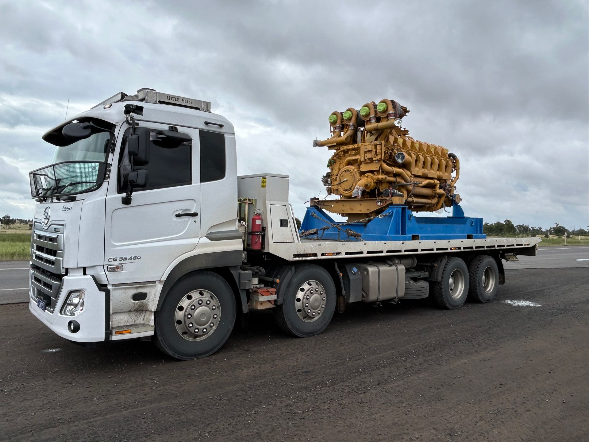 A Car Is Being Towed By A Tow Truck On A City Street — Little Mates Towing & Transport Pty Ltd In Gladstone, QLD