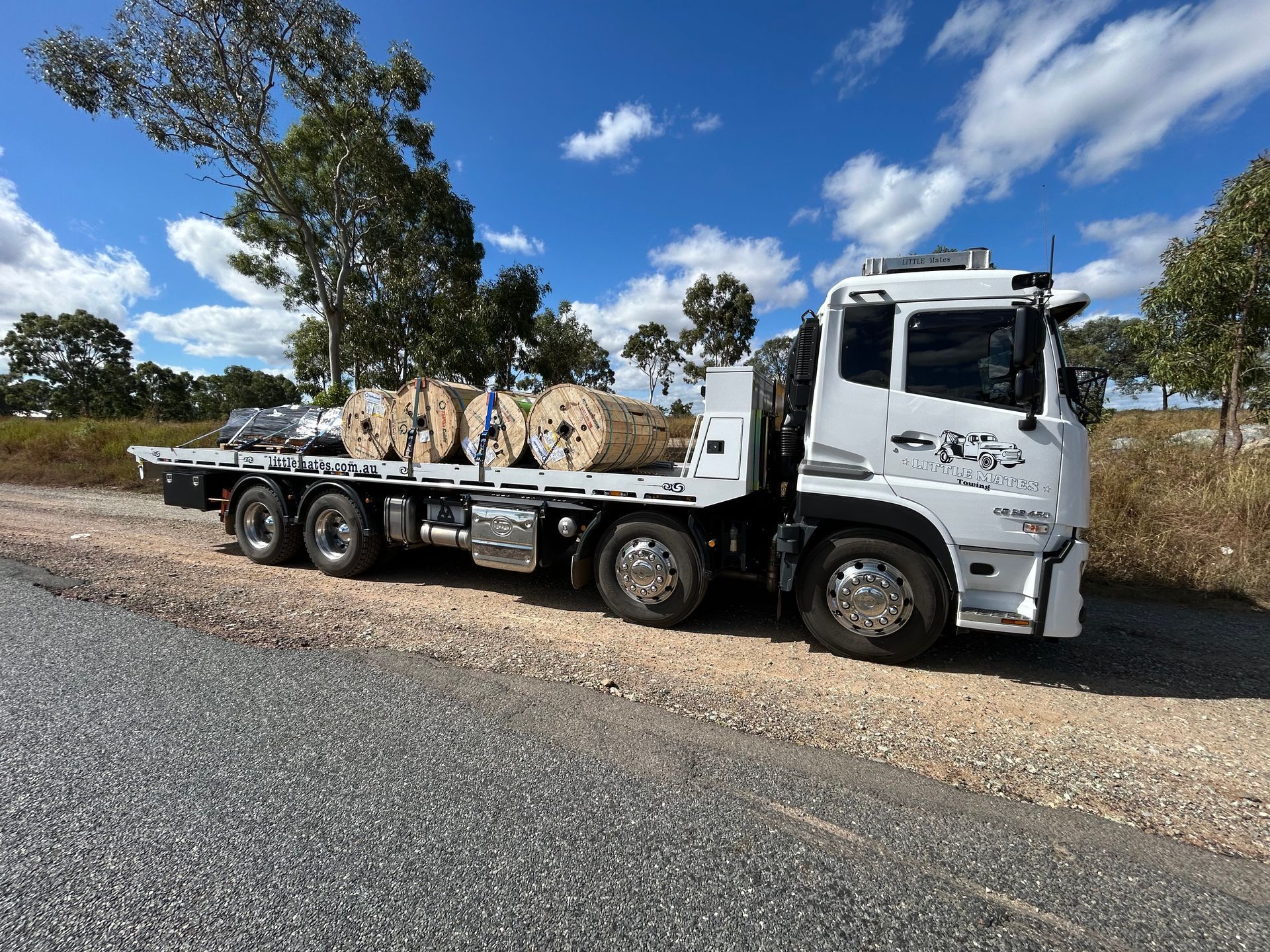 A Blue Tow Truck Is Carrying A White Car — Little Mates Towing & Transport Pty Ltd In Glenlee, QLD