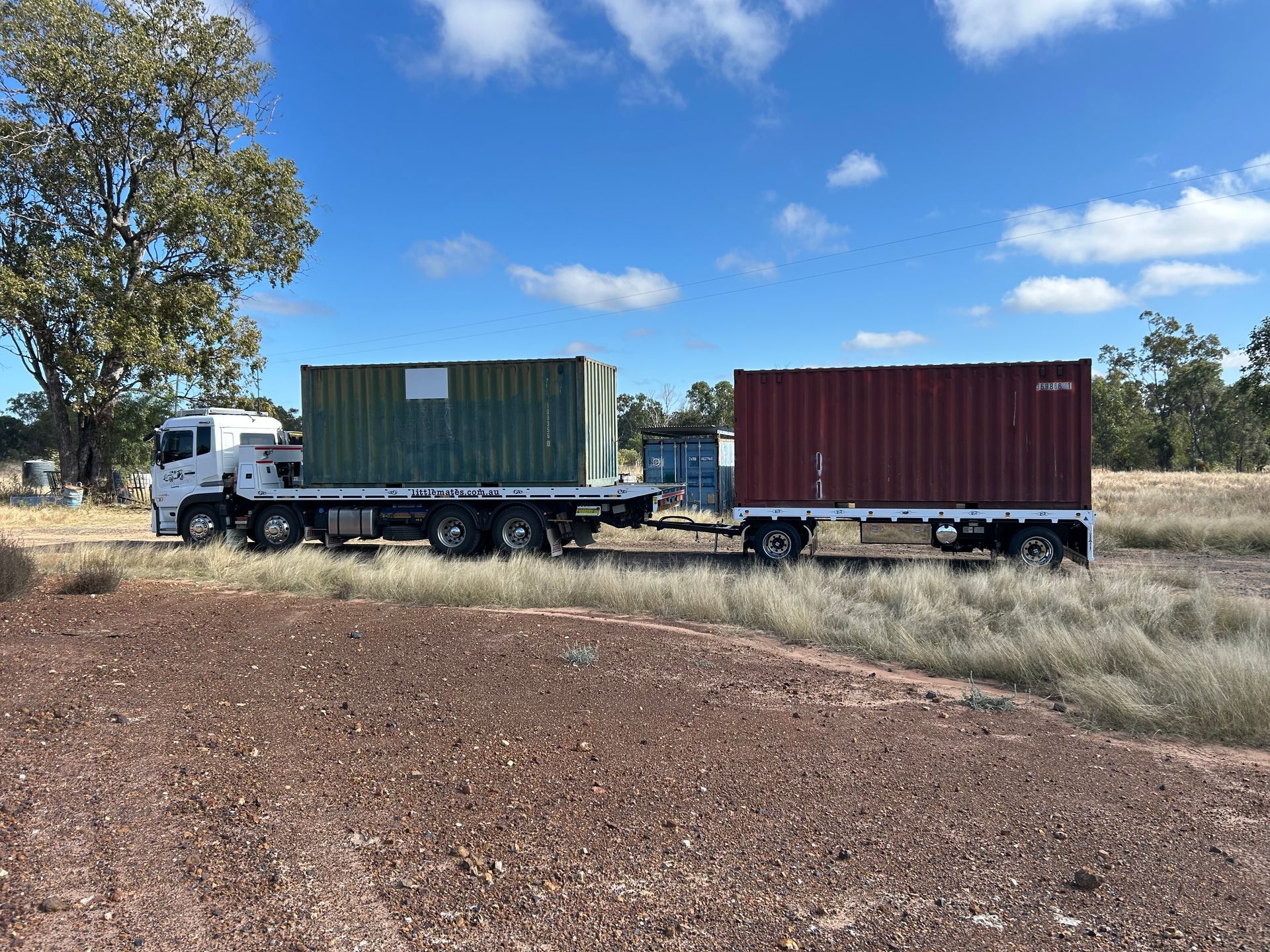 A Dumpster Is Sitting On The Back Of A Tow Truck — Little Mates Towing & Transport Pty Ltd In Yeppoon, QLD