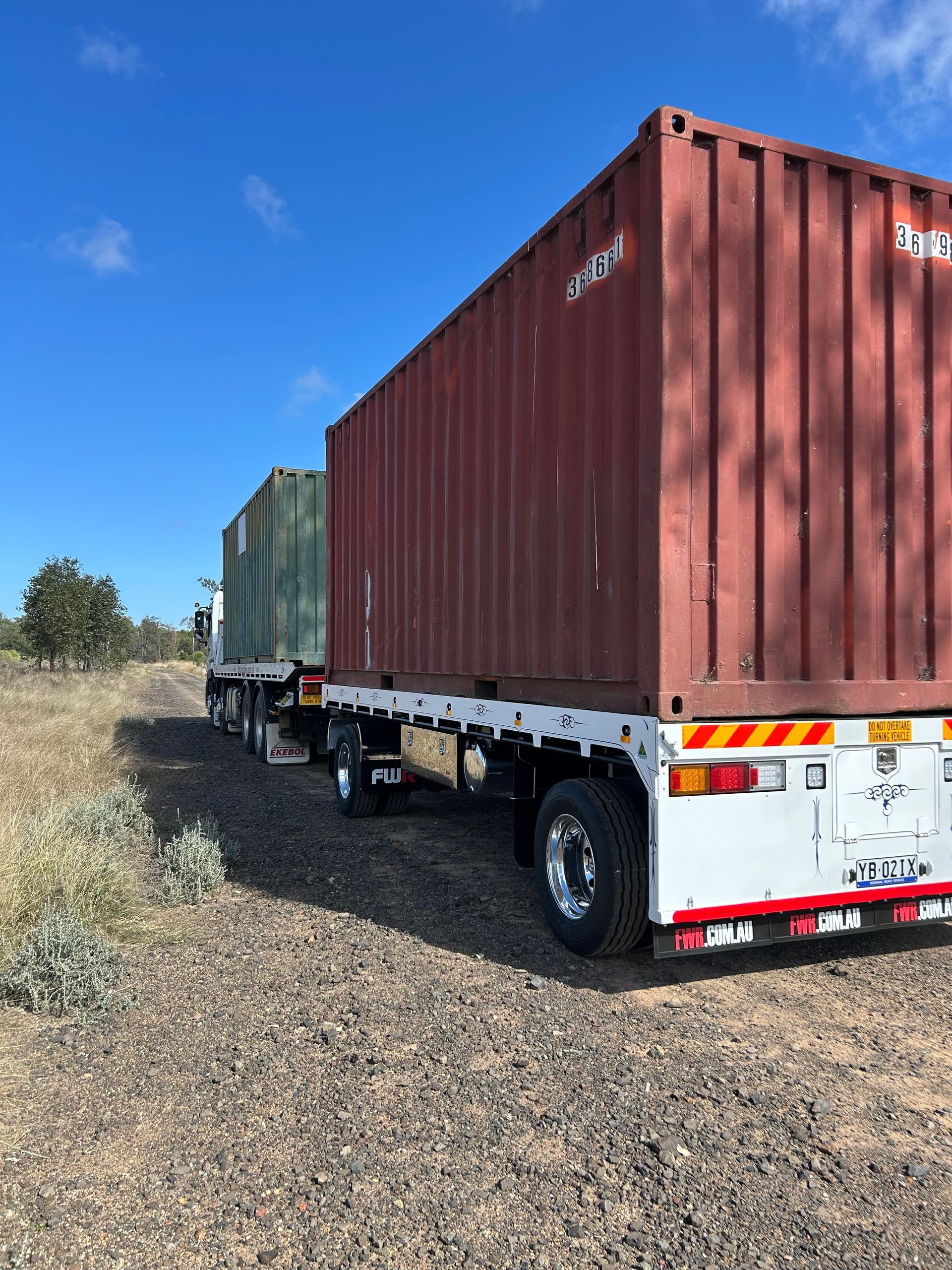 A White Truck With A Container On The Back Is Parked In A Field — Little Mates Towing & Transport Pty Ltd In Glenlee, QLD