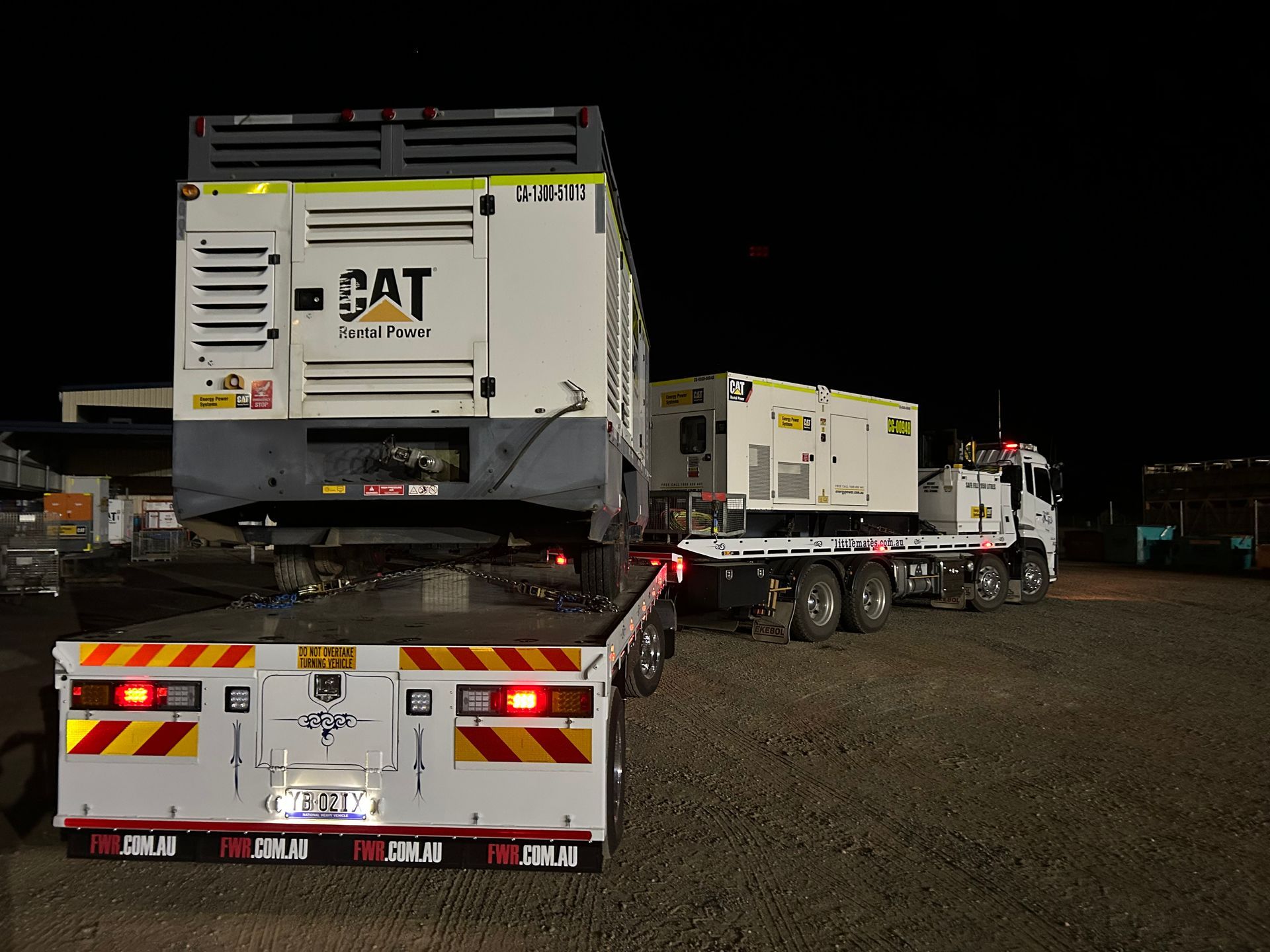 A White Tow Truck Is Carrying A Large Object On A Flatbed Trailer — Little Mates Towing & Transport Pty Ltd In Glenlee, QLD
