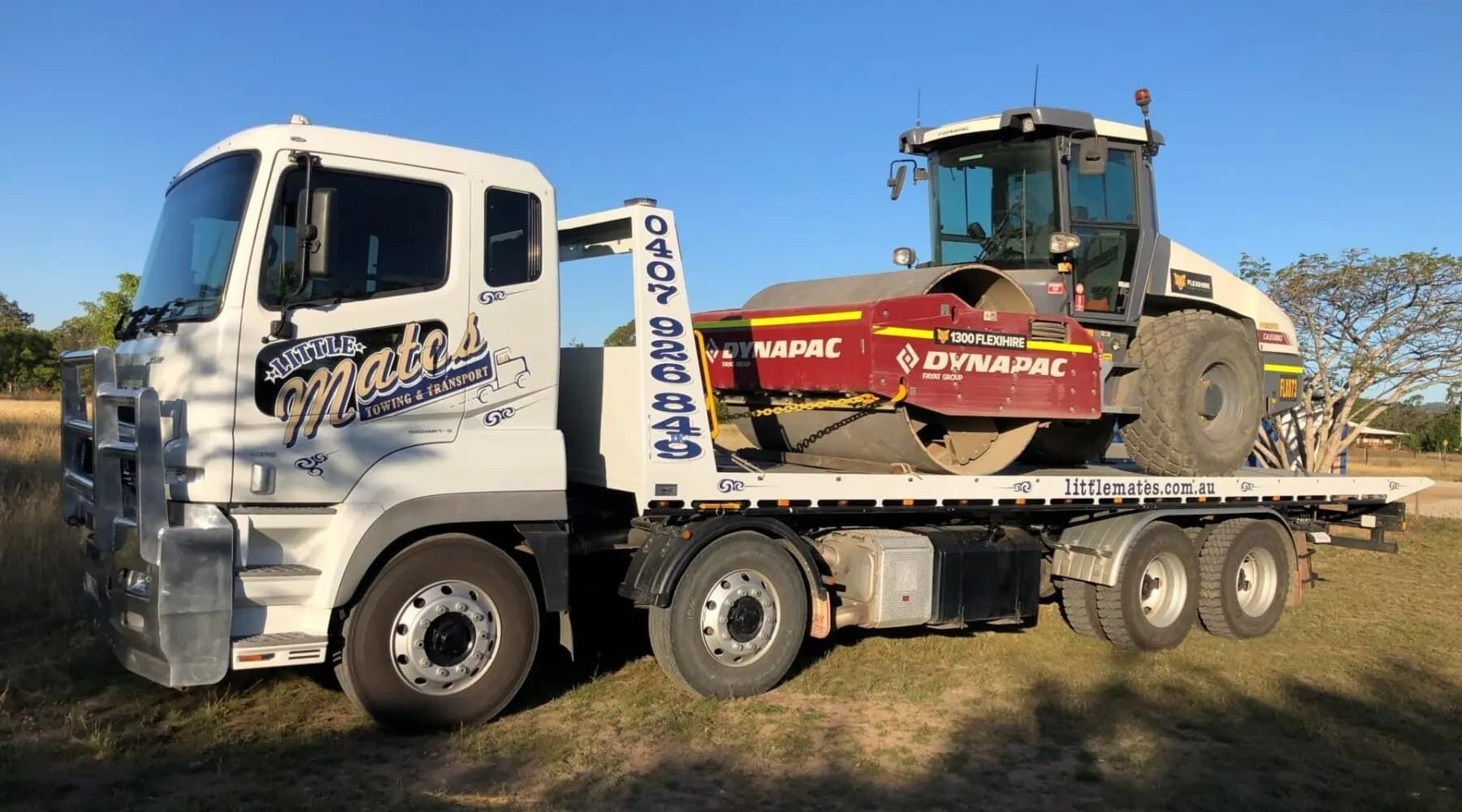 A Tow Truck Is Carrying A Tractor On The Back Of It — Little Mates Towing & Transport Pty Ltd In Glenlee, QLD