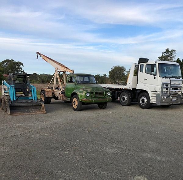 Three Trucks Are Parked In A Parking Lot  — Little Mates Towing & Transport Pty Ltd In Glenlee, QLD