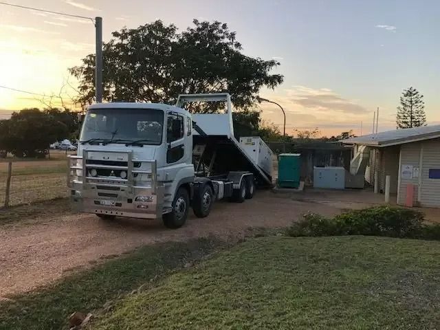 A Dump Truck Is Parked In Front Of A House On A Dirt Road — Little Mates Towing & Transport Pty Ltd In Glenlee, QLD