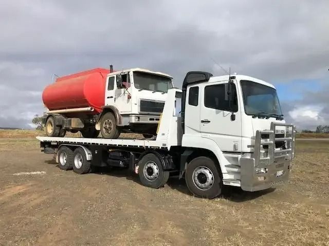 Two Trucks Are Parked Next To Each Other In A Field — Little Mates Towing & Transport Pty Ltd In Gladstone, QLD