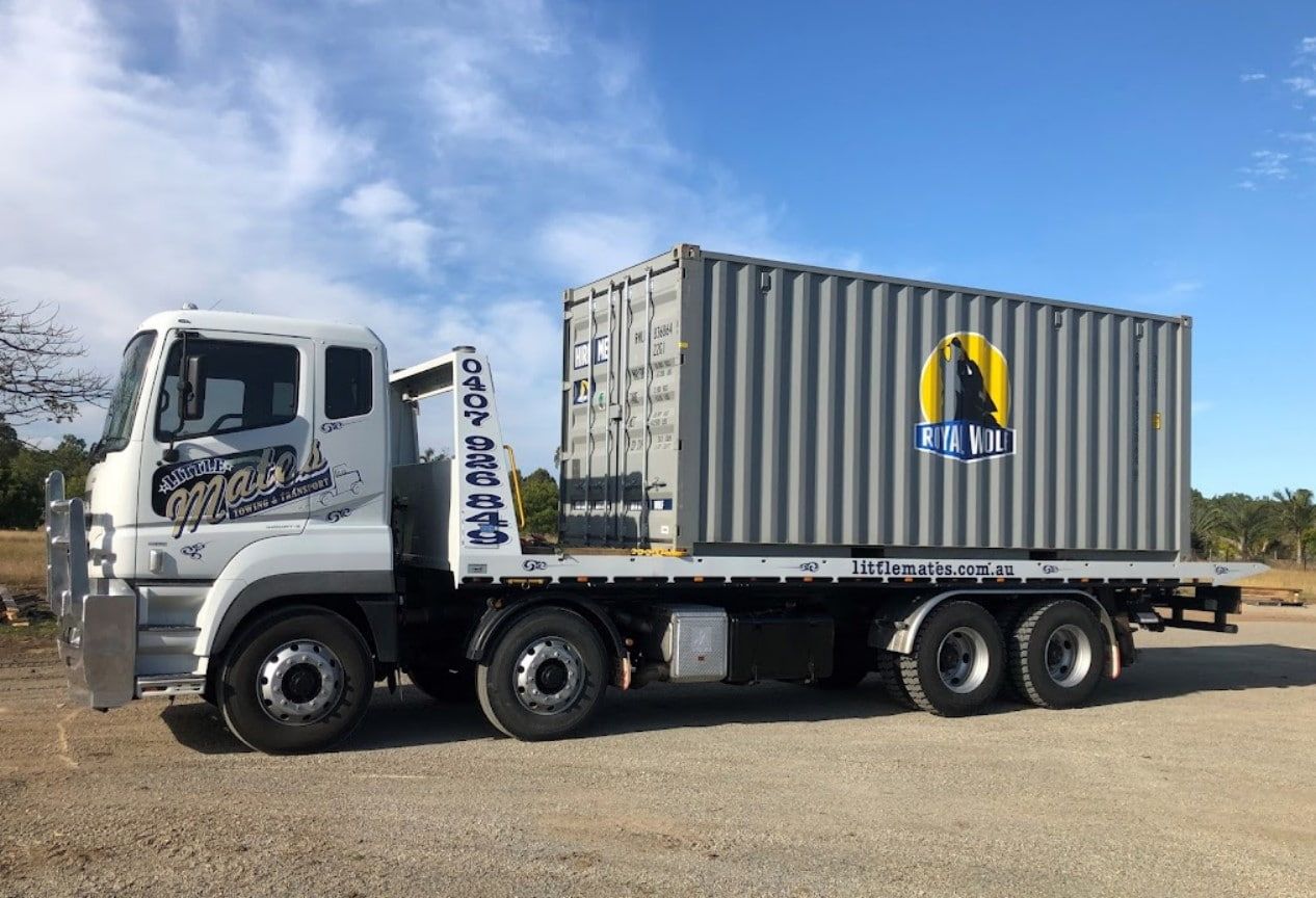 A Truck With A Container On The Back Is Parked In A Gravel Lot — Little Mates Towing & Transport Pty Ltd In Glenlee, QLD