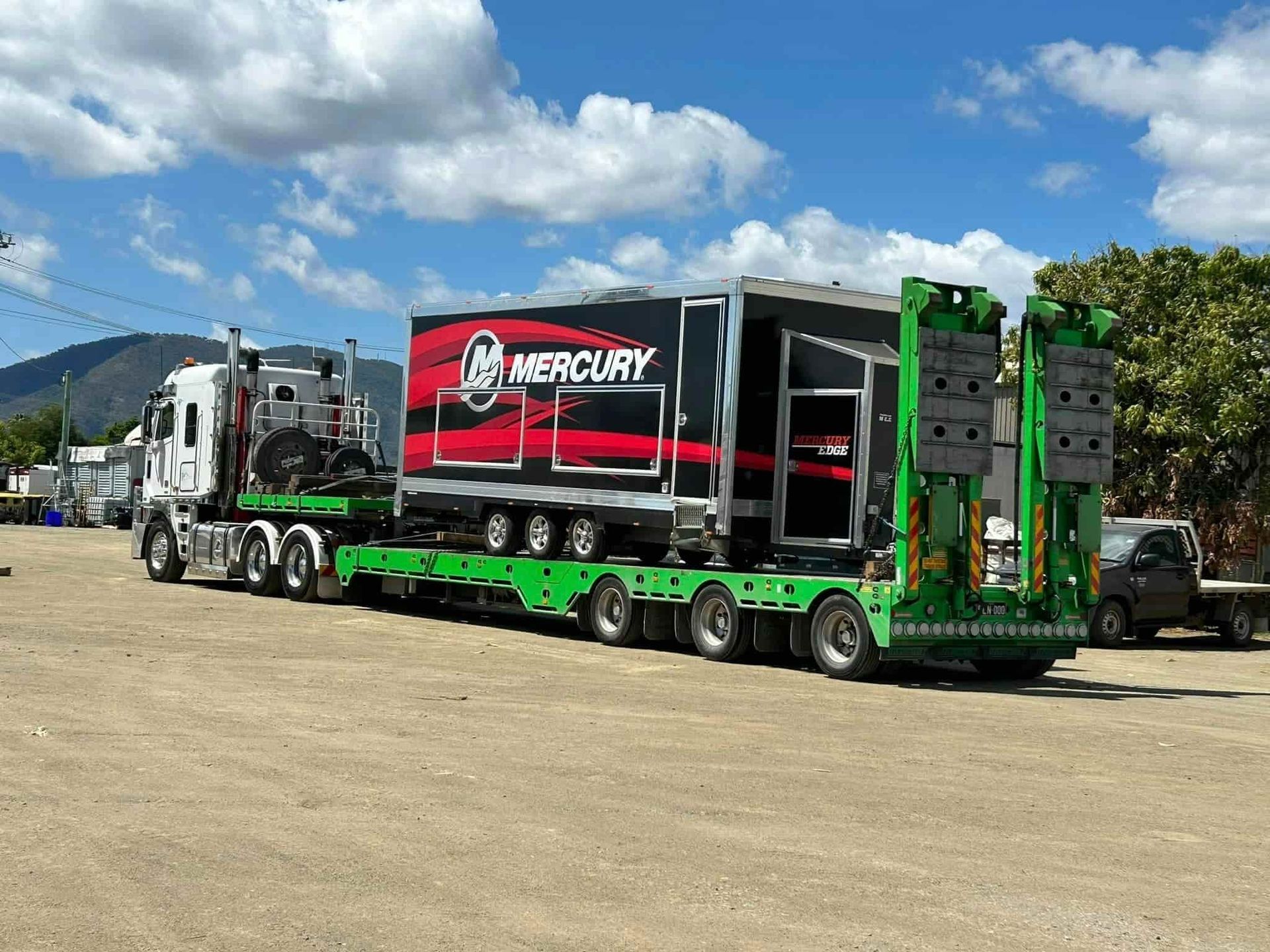 A Mercury Trailer Is Being Pulled By A Semi Truck In A Parking Lot — Little Mates Towing & Transport Pty Ltd In Emerald, QLD