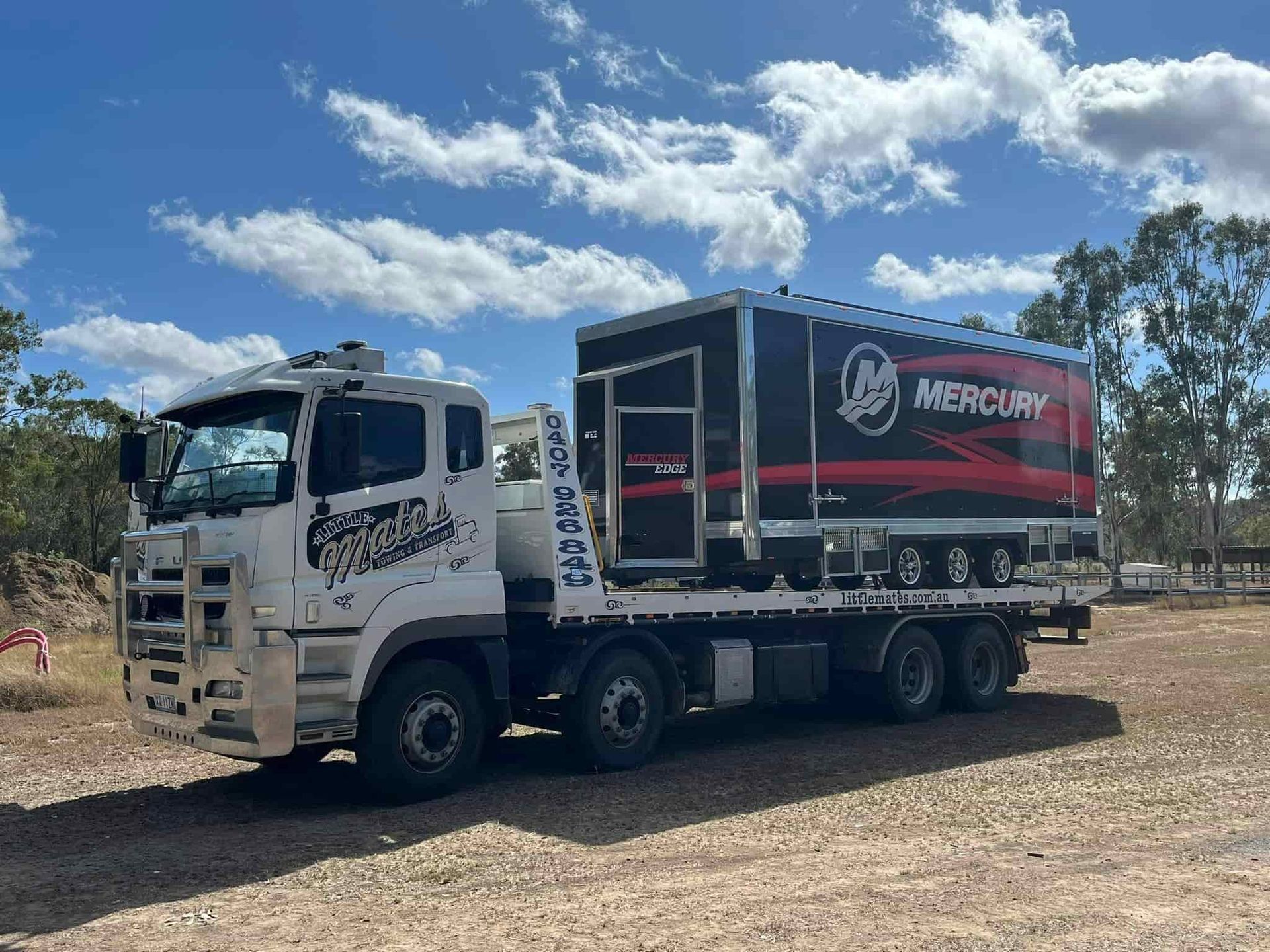 A Mercury Truck Is Parked In A Dirt Field — Little Mates Towing & Transport Pty Ltd In Gladstone, QLD